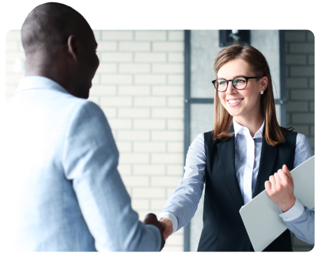 A man and woman shaking hands in an office, showing a professional relationship.