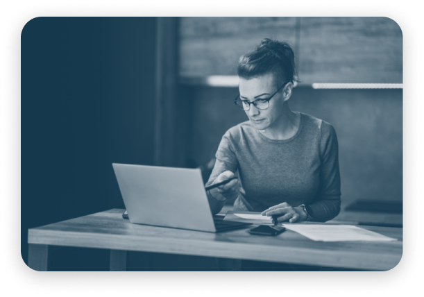 A woman sitting at a desk with a laptop, capturing voice input.