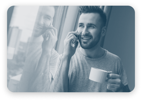 A man talking on a cell phone in front of a window while ensuring PCI compliance.