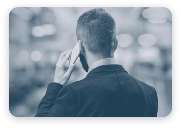A man in a suit having a conversation on his cell phone.